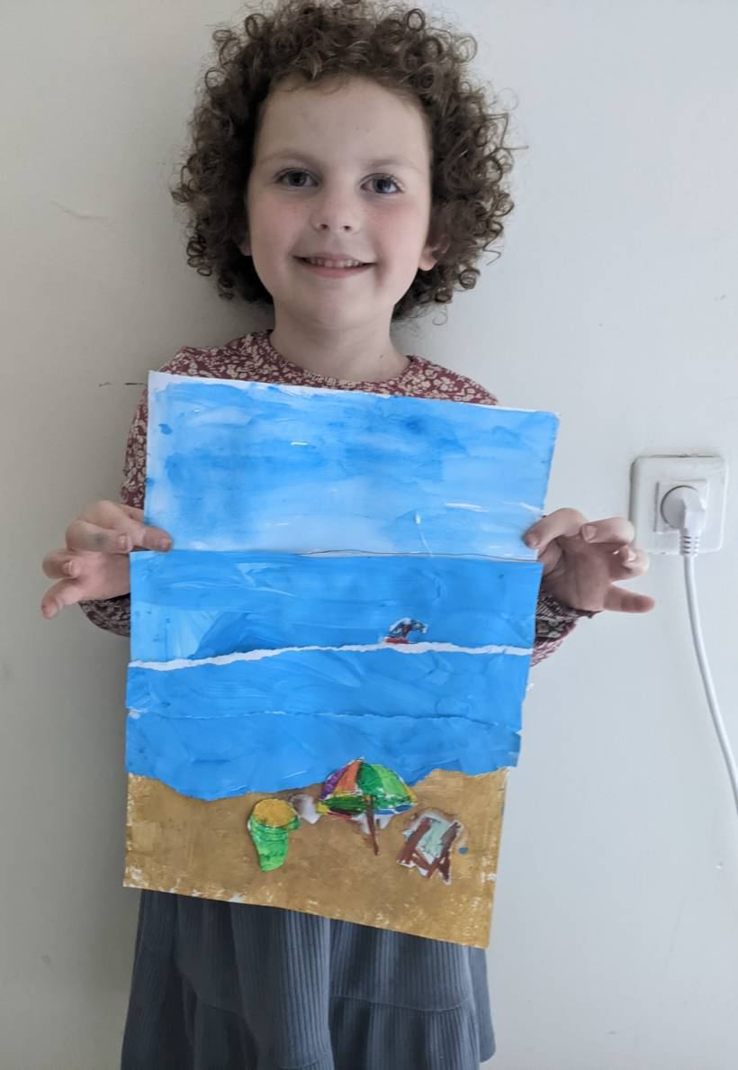 A proud boy holding up his painted beach scene