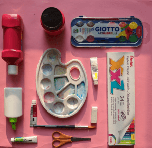 A beginner artist's workspace with watercolor paints, brushes, and supplies, illustrating how to start learning art.